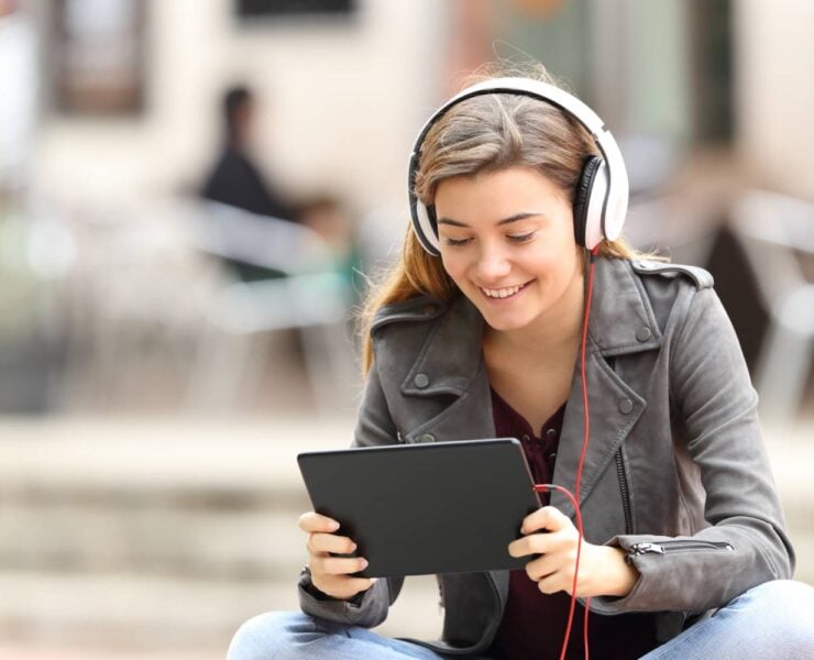 A happy woman watching a video on a tablet.