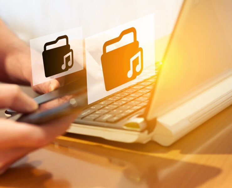 Eine Person die am Laptop sitzt und Musik herunterlädt